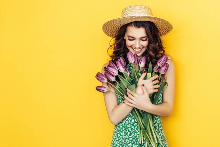 Lovely woman with purple tulips bunch